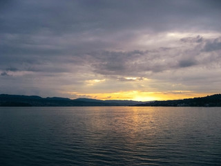 Beautiful sunset at Lake Zurich with sun reflecting from water.