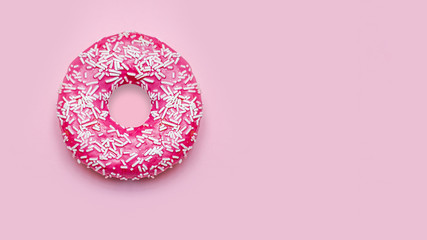 Donuts with icing on pastel pink background.