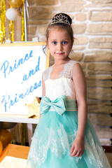 Portrait of girl dressed as bride in turquoise dress with diamond diadem