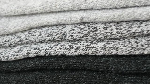 Close-up pile of knitted winter socks 4K panning footage