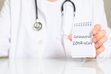 Arzt mit Block und dem Schlagwort Coronavirus