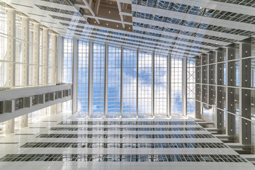 Abstract up view of a white building toward a pur blue sky with small white clouds