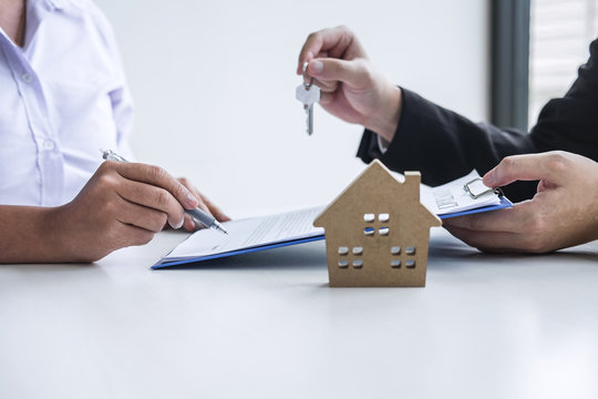 a couple holding a house shaped like a house with a house shaped like a house made of paper - Estate