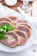 Cooked pork knuckle roll with chicken on a white plate, selective focus