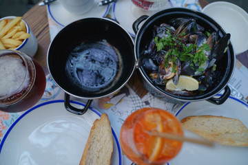 Mussels in a cauldron with cream sauce and herbs. Bar of mussels. Dinner with a beer. Dinner with...