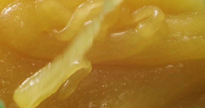 Close-up of honey dripping. Pouring honey on honeycomb.