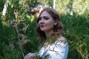 sad young girl at green bushes background