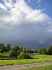 storm clouds nearing sunny field