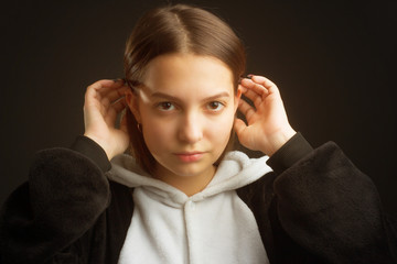 portrait of a brunette girl in the Studio on a plain black background in black and white pajamas with a hood