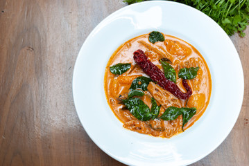 Thai Curry with vegetables on wooden table