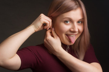 Fototapeta premium Portrait of the blonde in the red sweater with short sleeves. Studio shot on dark gray background