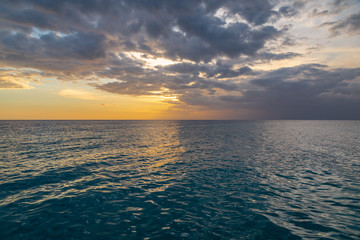 Beautiful sunset on the Caribbean, bright orange sun in the clouds.