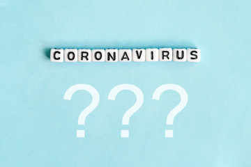 Coronavirus word next to question marks on blue background.