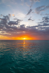 Fototapeta na wymiar Beautiful sunset on the Caribbean, bright orange sun in the clouds.