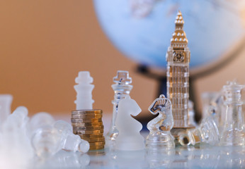 Selective focus of Stack new British one pound coins and souvenir of Big Ben tower with wood knight chess on board game in retro filter,Business leader and Brexit confrontation solve problems concept