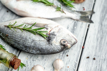  Fresh dorado fish with spices and ingredients for cooking on a wooden table background