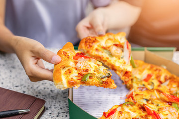 office people group taking and sharing pizza slices from box on table. Employees team workers...