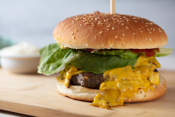 Tasty grilled home made burgers cooking with beef, tomato, cheese, cucumber and lettuce