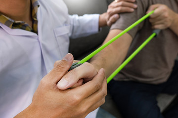 instructor assisting senior doing exercise working out in clinic strengthening muscles and developing joints.
