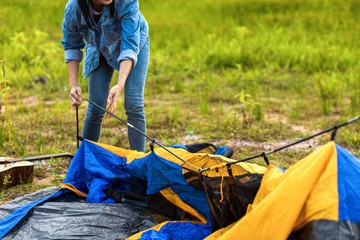 People Pitch a tent on the ground near the lake. Relaxing, traveling, long weeked, holiday concept.