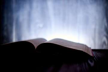 An open book with a glow in the background.