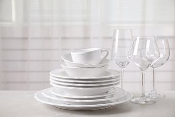 Set of clean tableware on light grey marble table