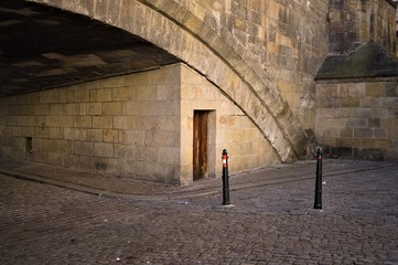 Wooden door under an old stone bridge (Prague, Czech Republic, Europe)