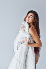 Woman covering her body by towel in the studio against white background