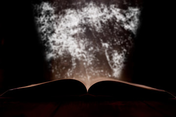 An open book with a glow in the background.