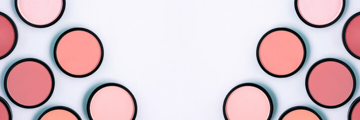 Pink blush and compact powder on a pastel blue background. Banner. Place for text, design. Top view.  Trending colors. Makeup. Cosmetic products. Tonal foundation. Flat lay, Layout. Beauty concept. 