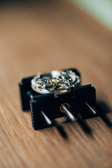 Selective focus of open wristwatch on movement holder on table