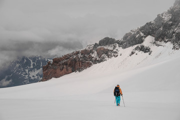 Man with a backpack is walking on a mountainside
