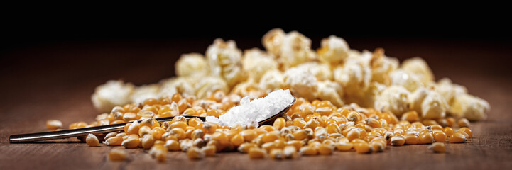 panorama or banner with raw corn and popcorn