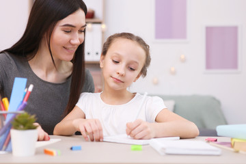 Mom helps the girl to do homework. Children and parents.