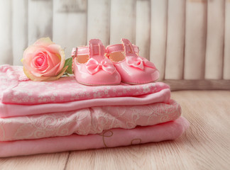 Baby clothes and baby shoes for a newborn girl in pink