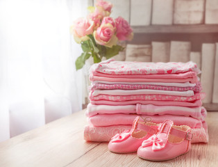 Baby clothes and baby shoes for a newborn girl in pink