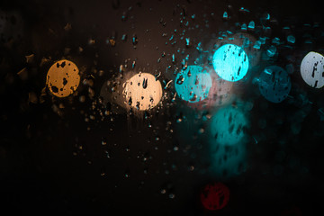 glare on wet glass at night. raindrops on the window. city lights at night.
