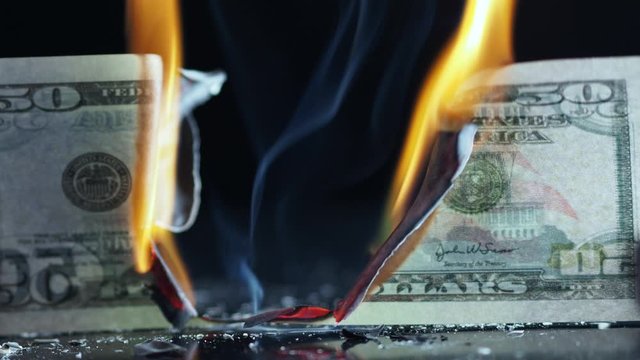 Burning 50 ten-dollar bill. Financial crisis. Money banknote on a black background, burning and Smoking, natural shooting