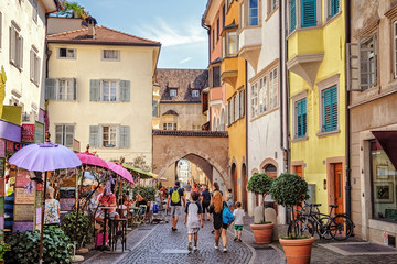 Tourists walking along Via Dr. Josef Streiter in Bolzano, South Tyrol, Italy - obrazy, fototapety, plakaty