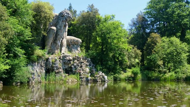 Firenze province local landmarks of tuscany region. the majestic big statue of Colosso dell Appennino giant statue and pond in public gardens of Pratolino near Florence in Italy - horizontal panning 