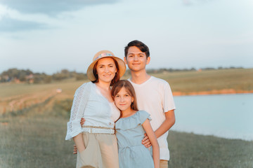 Woman with teenage son and daughter smiling. Family portrait