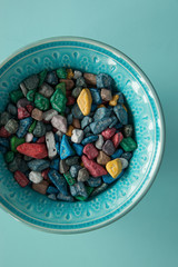 Colorful sea pebble candy, chocolate candy on blue background.