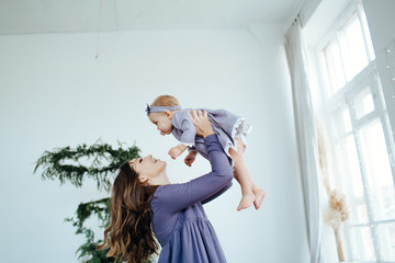 Mom smiles and kisses her daughter. A happy family. Portrait of a mother.