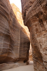 Path through the Siq, which is the narrow gorge passage that you walk along to reach Petra, Jordan.