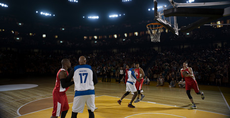 Fototapeta premium Basketball players on big professional arena during the game. Tense moment of the game.