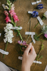 A girl in a Pink Dress Looks at Fresh Flowers on a Board