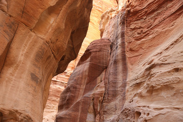Looking up from the sandstone path through the Siq, which is the narrow gorge passage that you walk along to reach Petra, Jordan.