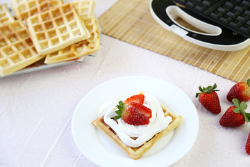 Waffle com morando e chantilly no prato em branco na mesa