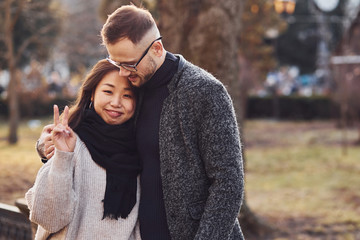 Happy multiracial couple together outdoors in the city. Asian girl with her caucasian boyfriend