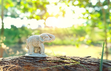 Elephant figurine on natural summer background. Thai white elephant statue, national culture...